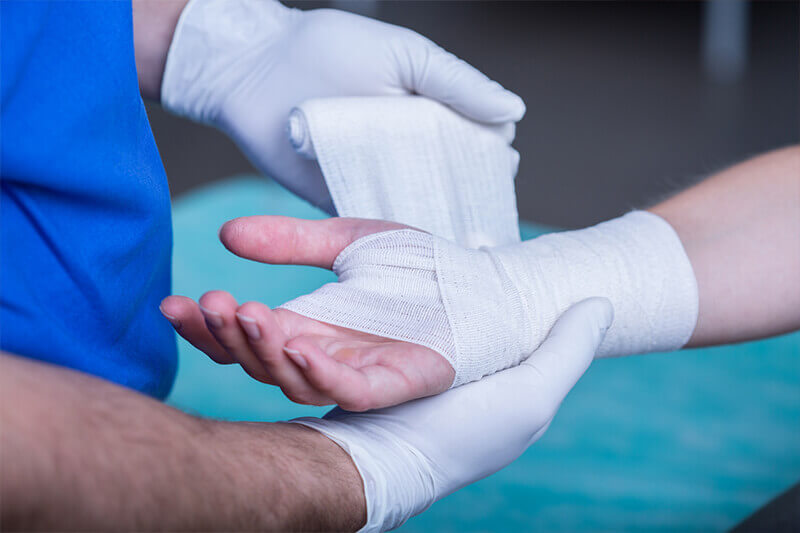 doctor bandaging injured hands